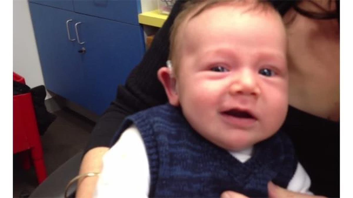 Imagem Bebê sorri ao ouvir pela primeira vez